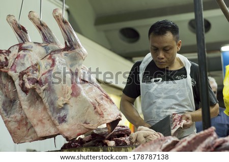 KUALA LUMPUR, MALAYSIA-FEB 26: Unidentified mutton seller at Chow Kit wet market cut the fat mutton in Kuala Lumpur, Malaysia on February 26, 2014