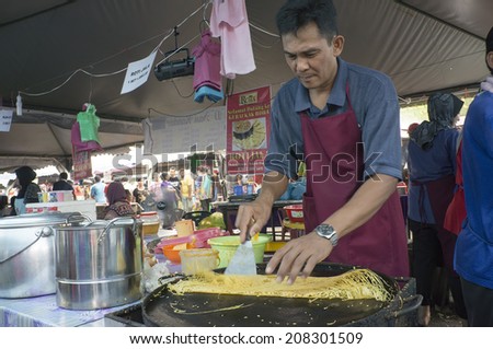 KUALA LUMPUR - JULY 10: Unidentified street food vendor, sale traditional malay food called roti jala (net bread) to his customers during iftar at Langkawi island, Malaysia on July 10, 2014