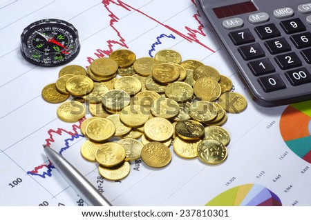 Conceptual of Gold Investment success with calculator, compas, ballpoint and graph on the background