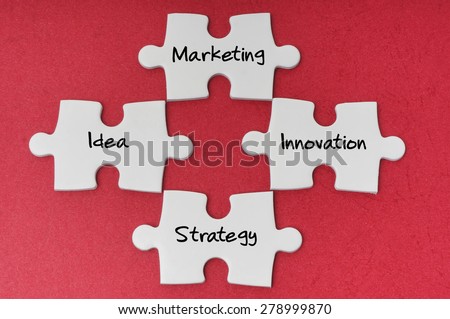 Puzzle with word marketing, idea, strategy and innovation isolated on red background