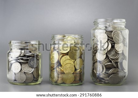 Three different size of jars full with coins - Financial Concept
