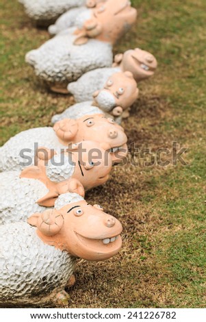 sheep sculpture is on grass background