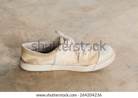 Old white sneaker on  cement floor