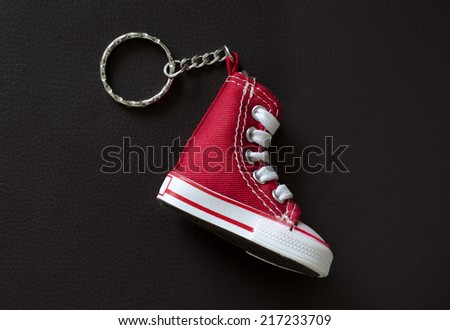 Key chain with mini red basketball shoe on leather pad