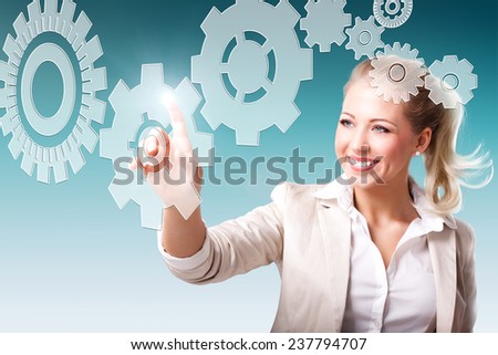 young businesswoman touching a virtual cogwheel in a more complex system