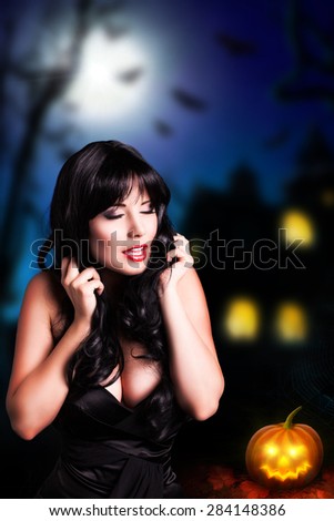 attractive black haired woman in front of a halloween house