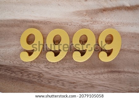 Golden Arabic numerals 9999 on a dark brown to white wood grain background. Foto stock © 