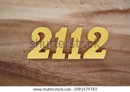 Golden Arabic numerals 2112 on a dark brown to white wood grain background. Foto stock © 