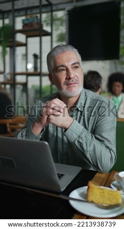 Thoughtful older businessman seated at coffee shop in contemplation. Pensive senior executive thinking about business looking out window in Vertical Video SS Photo stock © 