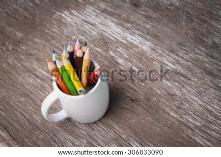 color pencil in a cup on wooded
