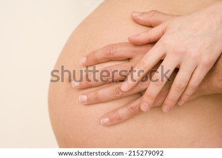 Young man with hand on pregnant woman\'s stomach, close-up