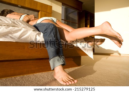 Young woman lying atop man on bed