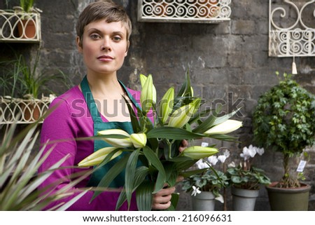 Female florist with bunch of flowers, portrait