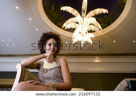 Young woman with hand of cards, portrait, low angle view