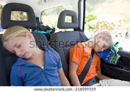 Brother and sister (8-12) asleep in back of car, close-up