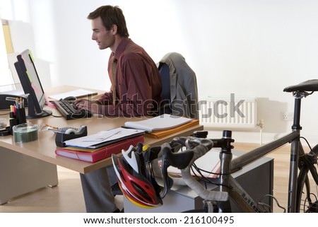 Man at desk in office, side view