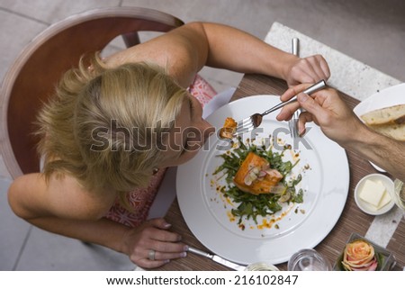 Man feeding woman at dinner table, overhead view