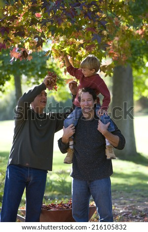 Multi-generational family doing yard work in autumn