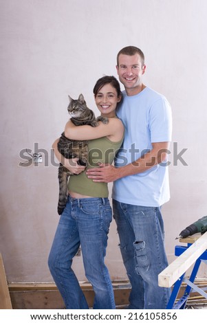 Young couple, woman with cat, smiling, portrait