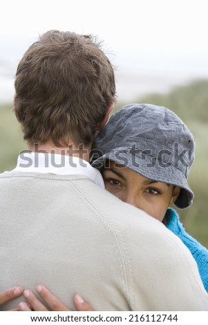 Young couple hugging outdoors, close-up