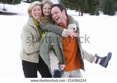 Young happy family standing in snow