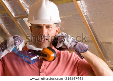 Construction worker with hard hat, goggles and ear protectors