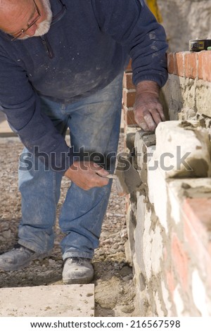 Man bricklaying wall with trowel