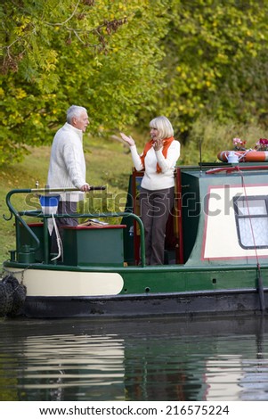 Woman gesturing to man on boat in canal