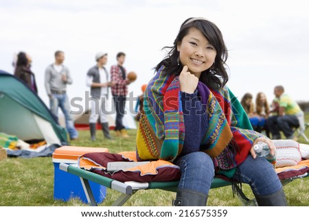 Young woman wrapped in blanket attending outdoor festival