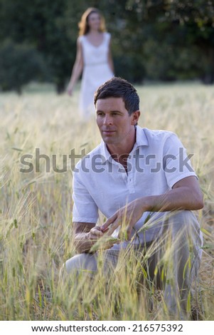 Man crouching in rural field