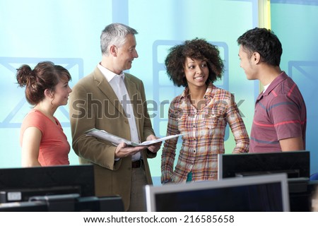 Teacher talking with students in computer lab