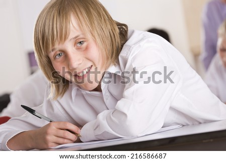 School boy taking test on desk in classroom