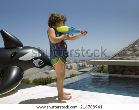 A boy playing with a water gun.