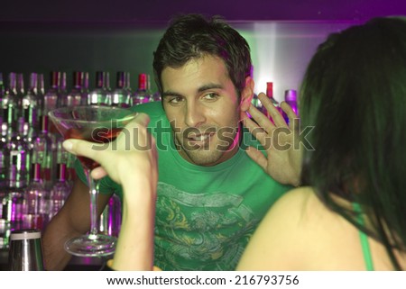 Bartender trying to listen to woman at bar counter
