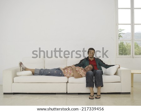 Portrait of a gay man with his head on his partner\'s lap