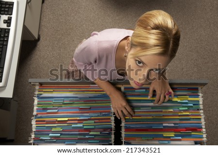 Portrait of a businesswoman searching a file in a filing cabinet drawer
