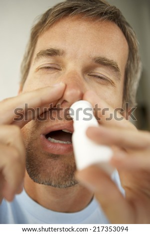 Close-up of a mid adult man using nasal spray