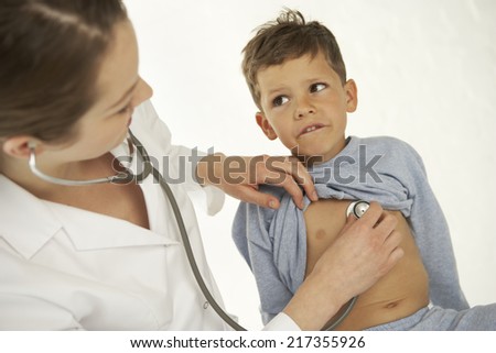 Side profile of a female doctor examining a boy with a stethoscope