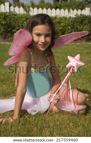 Portrait of young girl with fairy wings and wand