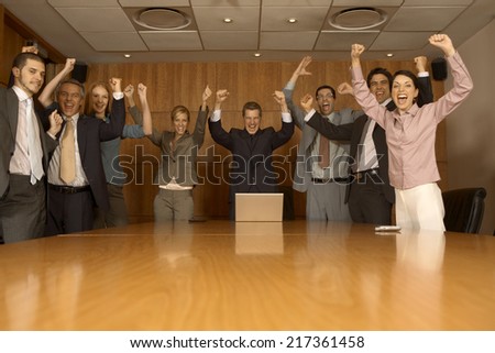 Group of business executives celebrating in a board room