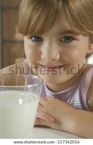 Happy young girl with glass of milk