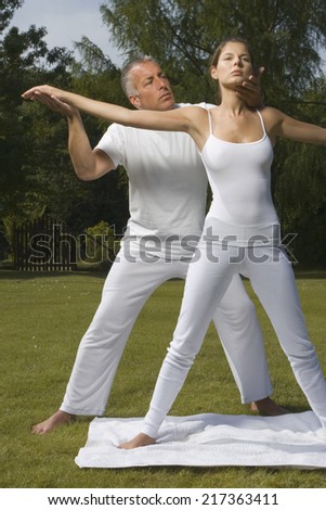 Yoga instructor teaching yoga to a young woman