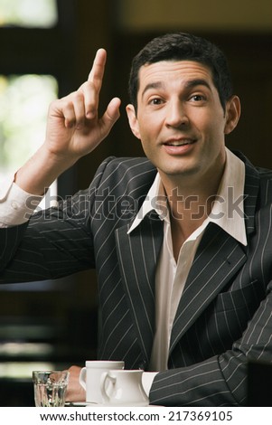 Portrait of a young man pointing upwards with his finger