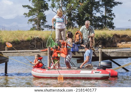 Multi-Generation Family Enjoying Boat Trip On Lake