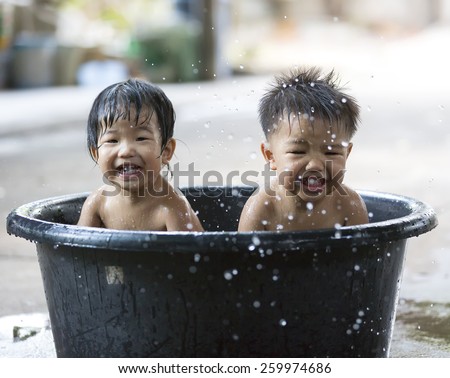 Happy twin brother and sister play and bath