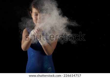 Little gymnast girl applying white powder