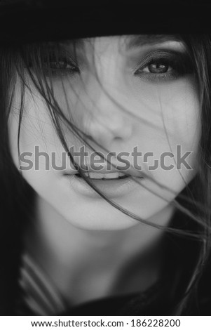 black and white portrait of beautiful girl with magic eyes in a hat