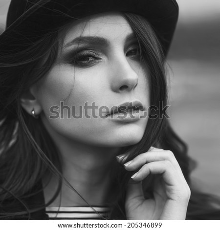 black and white portrait of a beautiful girl in hat at the sun outdoor