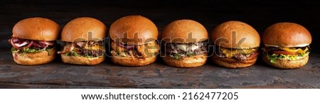 Burger with fried potatoes on a set table in the restaurant in the sunshine