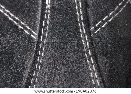 Texture of Leather being sewn. Black suede with white stitch.